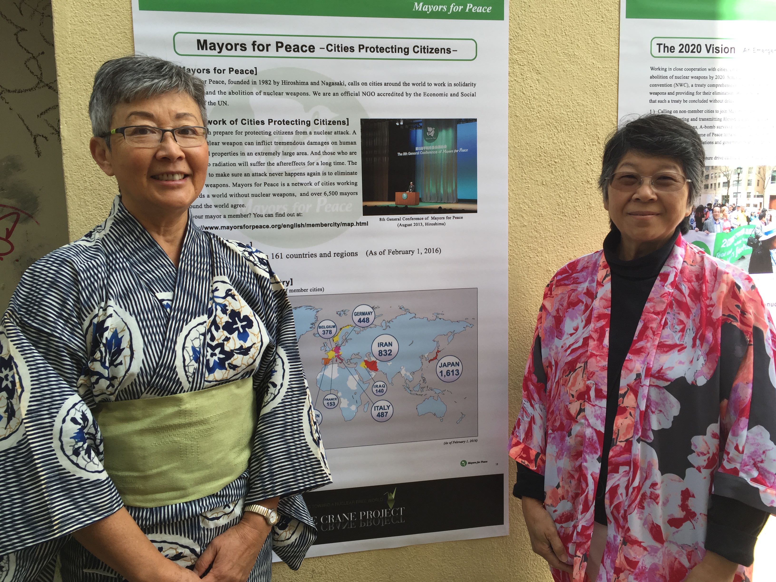 Sachiko Knappman and Phyllis Tajii in front of the Mayors for Peace Exhibit from Hiroshima